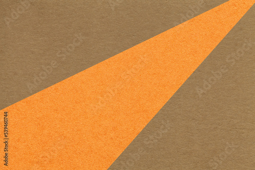 Texture of old craft dark brown and orange color paper background, macro. Vintage abstract umber cardboard