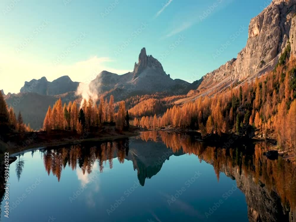 Drohnenflug am Lake Fedare / Lago di Federa in den Belluner Dolomiten zum Sonnenaufgang. Es ist Herbst und der Wald am See leuchtet gelb. Belluner Dolomiten 3