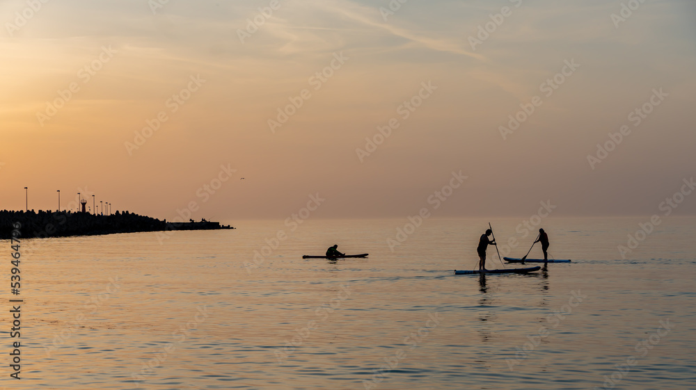 Schwimmen auf einem Stend up Paddle bei Sonnenuntergang.
Kolberg, Baltic, Polen - Sommer 2022