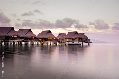 Apartments over the water during sunset in French Polynesia