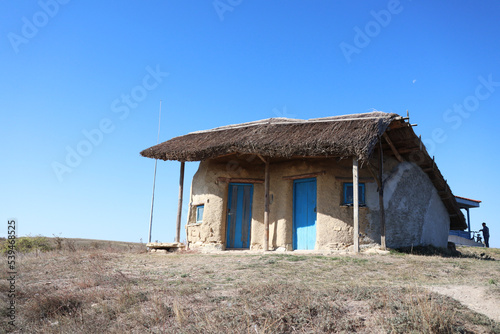 old fashioned rural traditional construction with reed house top blue painted made of wood or clay
