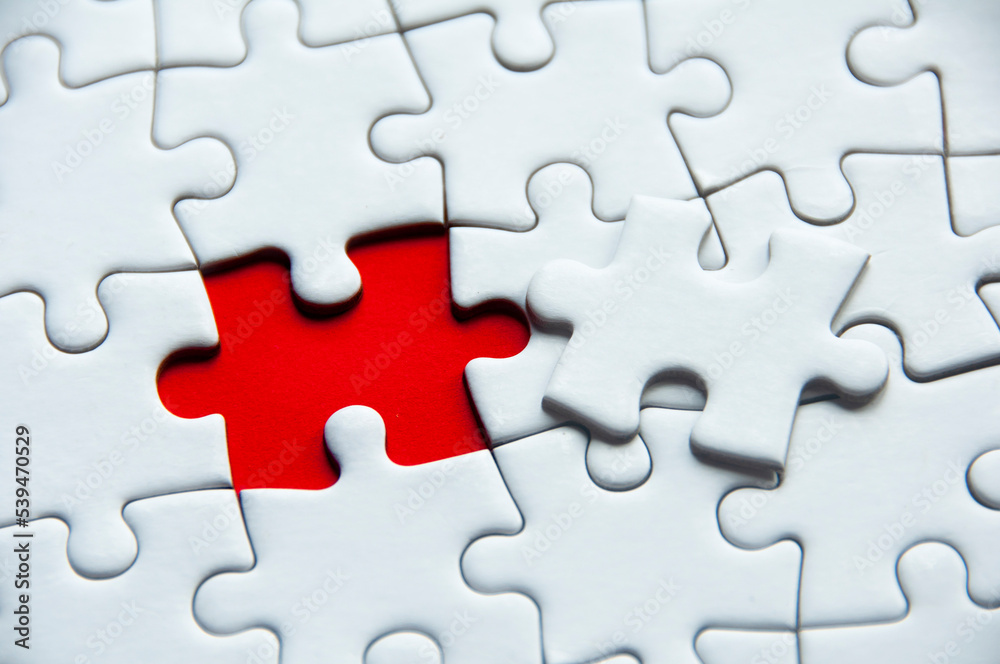 White jigsaw puzzle on red cover background with customizable space for text or idea. Copy space White jigsaw puzzle on red cover background with customizable space for text or idea. Copy space