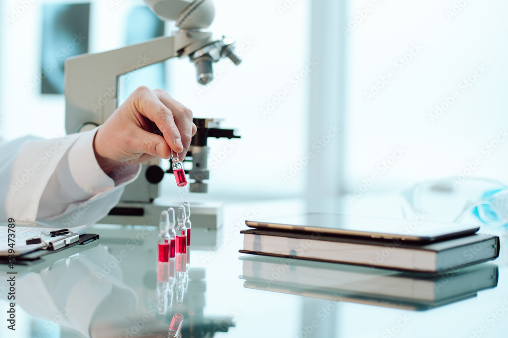 scientist looking at samples with a new vaccine. scientist looking at samples with a new vaccine.