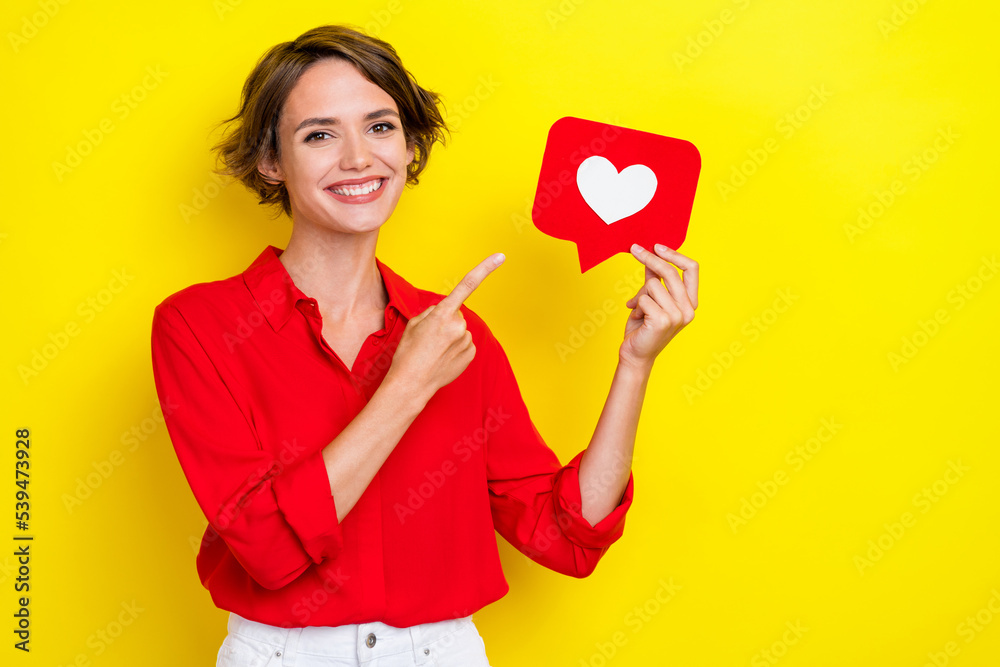 Portrait of girlish positive cheerful woman with bob hairstyle wear red shirt directing empty space isolated on yellow color background Portrait of girlish positive cheerful woman with bob hairstyle wear red shirt directing empty space isolated on yellow color background