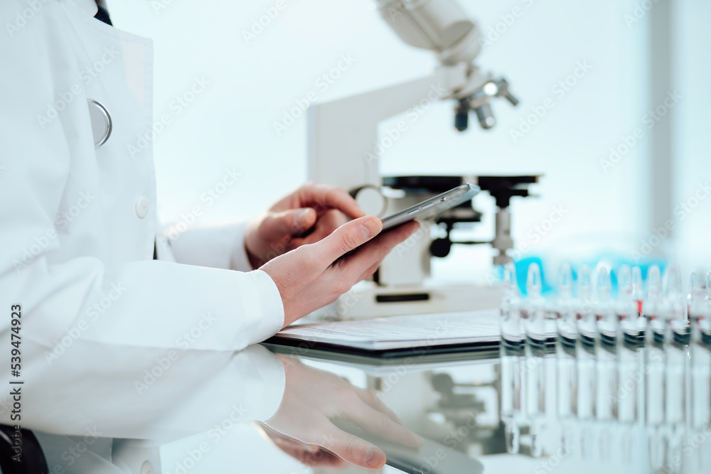 scientist using a digital tablet while working in the lab.