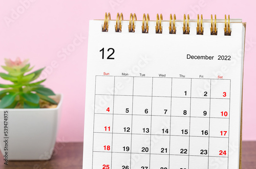 Close up the December 2022 Monthly desk calendar for the organizer to plan 2022 year on wooden table background. photo