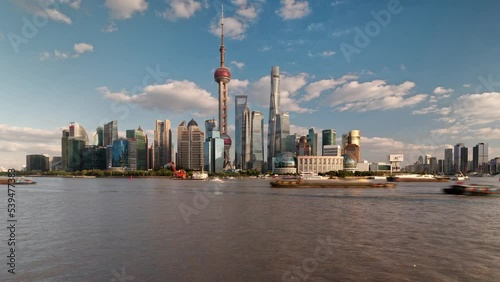 shanghai bund landmark buildings viewed from puxi in sunny cloudy day, ships sailing on Huangpu river, time lapse 4k footage, b roll shot. photo