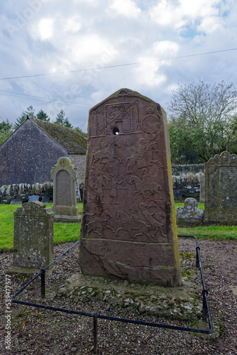 The Rear view of Aberlemno 2 Sculptured Stone in Aberlemno Kirkyard amongst the Gravestones of the Associated Graveyard, photo