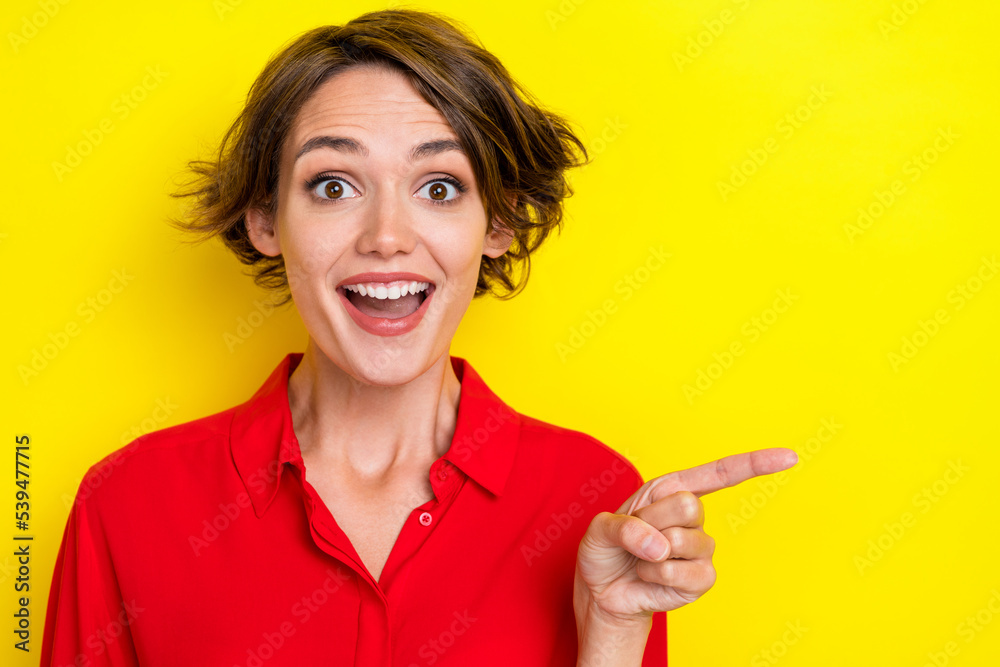Photo of positive ecstatic lovely woman with bob hairstyle wear red shirt directing empty space isolated on yellow color background Photo of positive ecstatic lovely woman with bob hairstyle wear red shirt directing empty space isolated on yellow color background
