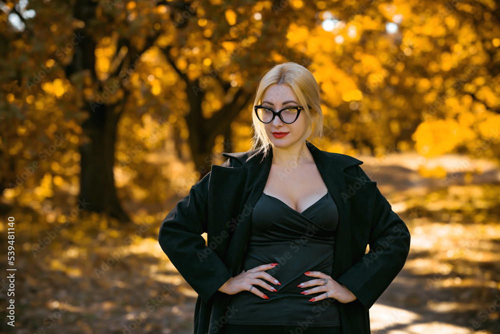 Autumn vibe concept. Stylish blonde woman at autumn garden with good mood. Lady with pretty accessorize and casual style on a nature Autumn vibe concept. Stylish blonde woman at autumn garden with good mood. Lady with pretty accessorize and casual style on a nature