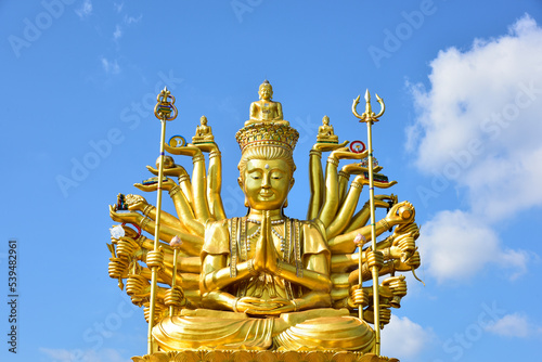 Canvas Print Big Golden Guan Yim or brass statue of Guanyin on a bright sky background