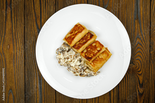 delicious pancakes with fried mushrooms on a plate. 