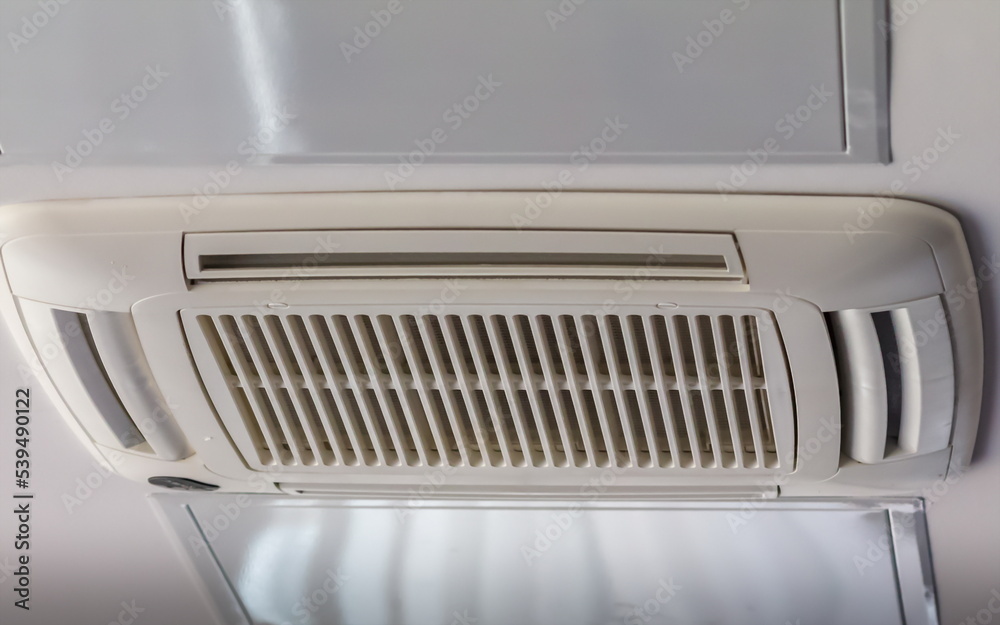 Air conditioner grille in close-up on the background of the office ceiling