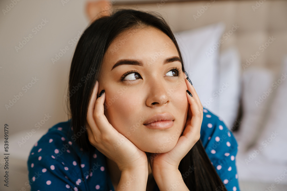 Portrait of young beautiful calm asian woman propping her head Portrait of young beautiful calm asian woman propping her head