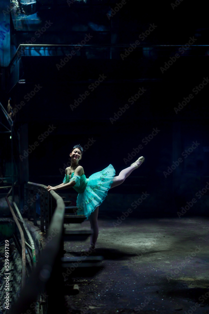 Fototapeta premium A young ballerina with a perfect body is dancing in a photo studio, dancers are dressed in fashionable outfits, this picture is taken in minimal style, showing the beauty of classical art like ballet.