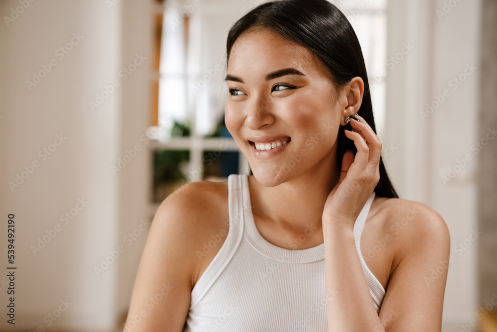 Young beautiful smiling happy asian woman in white sleeveless t-shirt Young beautiful smiling happy asian woman in white sleeveless t-shirt