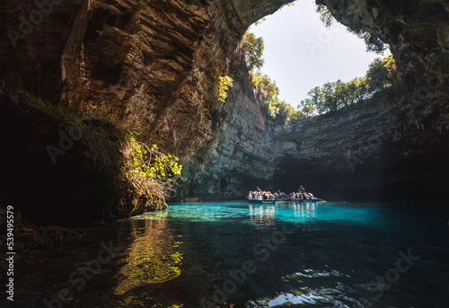 Melissani Cave Lake with floating boats with tourists in Sami, Greece.