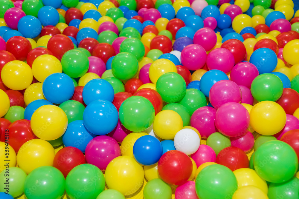 Many colour plastic balls from children's small town. Background texture of multi-colored plastic balls. Colorful plastic gum balls in kid playroom or playground for children's holiday party concept Many colour plastic balls from children's small town. Background texture of multi-colored plastic balls. Colorful plastic gum balls in kid playroom or playground for children's holiday party concept