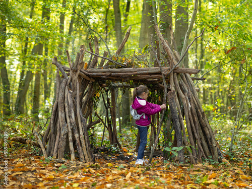 Tableau sur toile une petite fille et sa cabane en bois en forêt