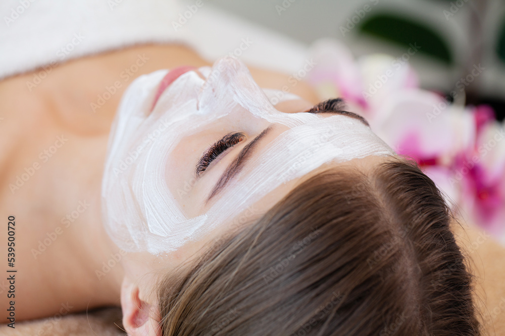 Fototapeta premium Attractive funny woman with a clay mask on her face.