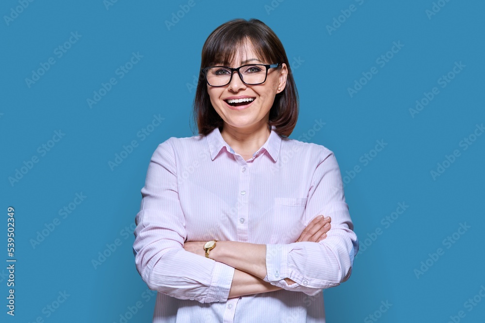 Portrait of confident middle-aged business woman on blue background Portrait of confident middle-aged business woman on blue background