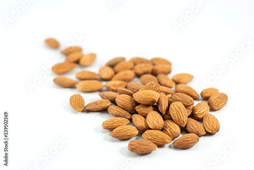 A pile of almonds on a white floor, selective focus.