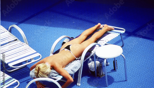 Sexy female beauty relaxing on a cruise ship deck outside. photo