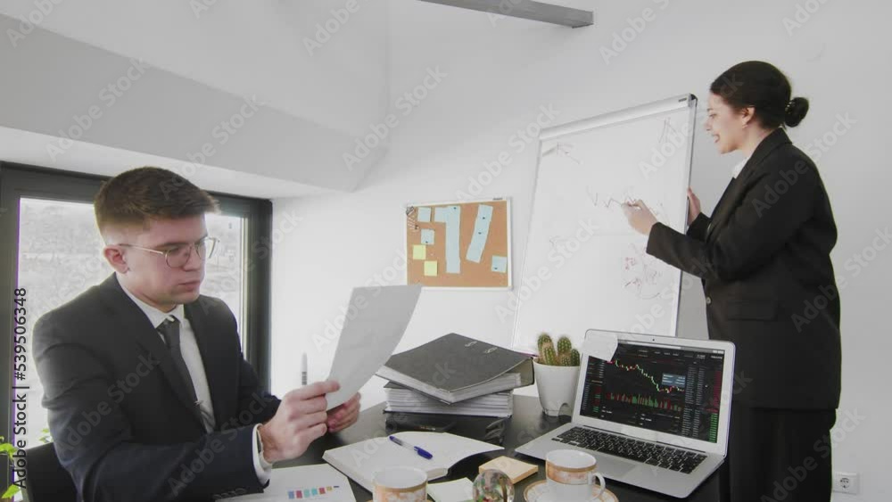 A business man and a woman, sitting at a table and solving business issues. Business people A business man and a woman, sitting at a table and solving business issues. Business people