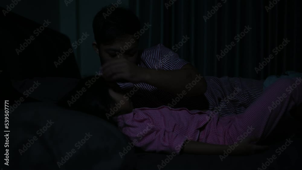 Dad and daughter sleep on the bed in bedroom,Watch cartoon with phone,Father day concept,Single dad,listen tale before sleep Dad and daughter sleep on the bed in bedroom,Watch cartoon with phone,Father day concept,Single dad,listen tale before sleep