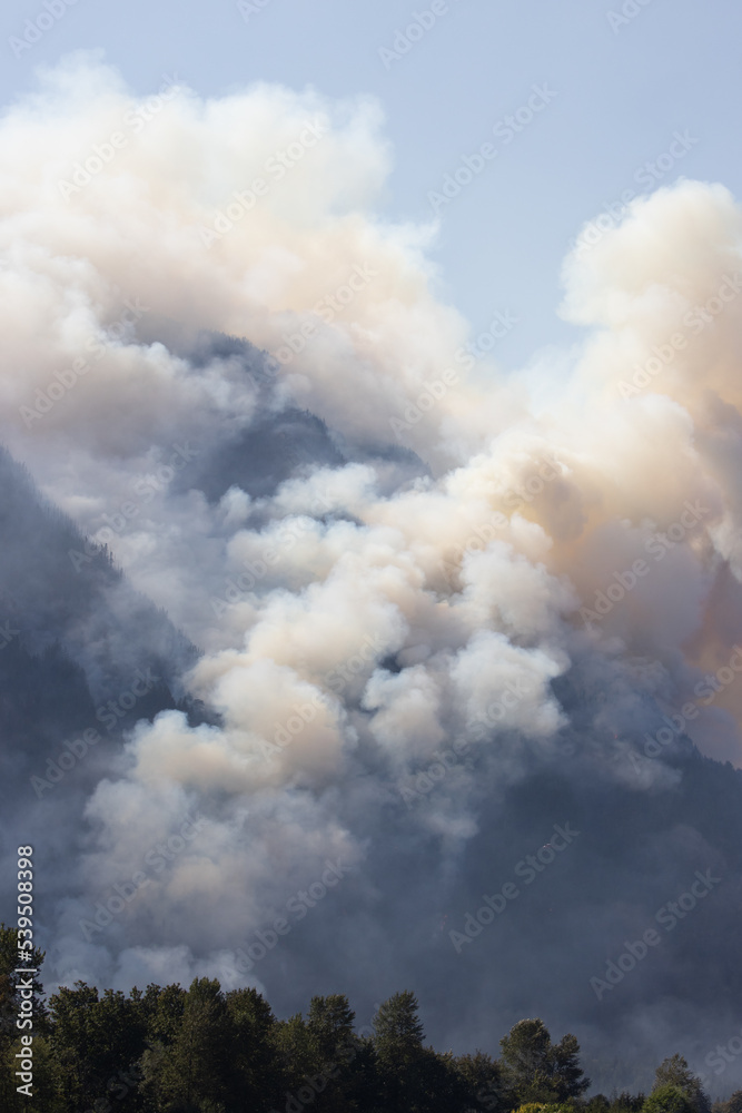 BC Forest Fire and Smoke over the mountain near Hope during a hot sunny summer day. British Columbia, Canada. Wildfire natural disaster BC Forest Fire and Smoke over the mountain near Hope during a hot sunny summer day. British Columbia, Canada. Wildfire natural disaster