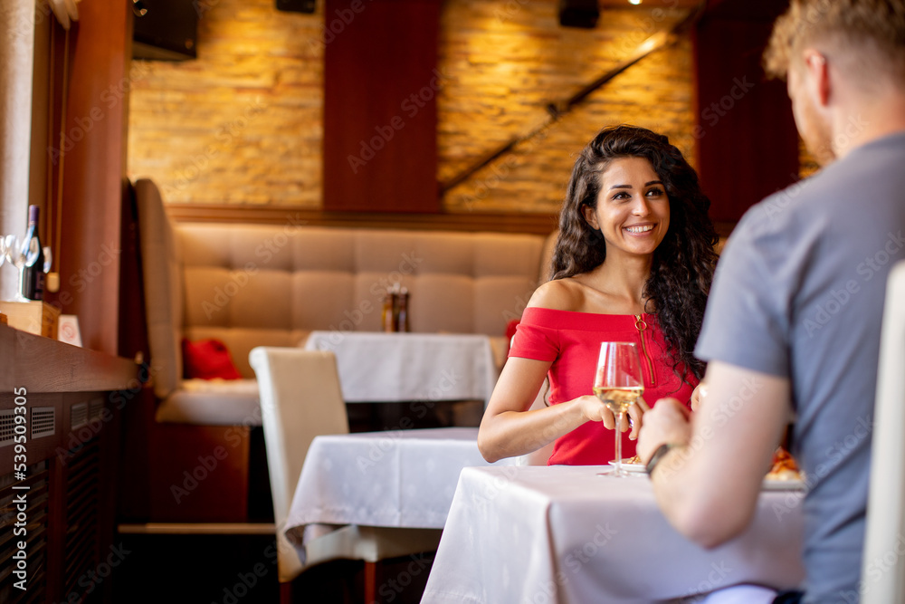 Young couple having lunch with white wine in the restaurant