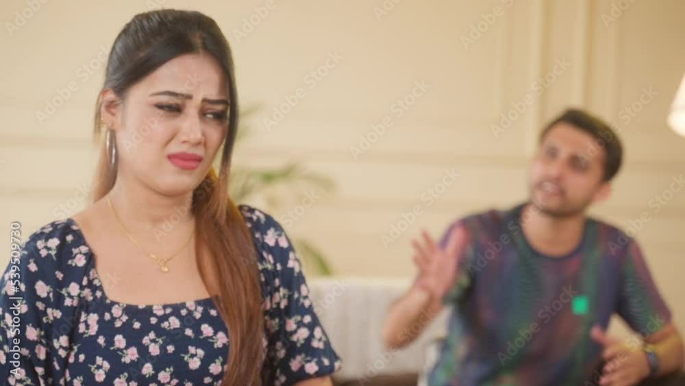 rack focus shot of irritated wife while talking with angry husband at home on couch - concpet of couple conflcit, family problems and break up. rack focus shot of irritated wife while talking with angry husband at home on couch - concpet of couple conflcit, family problems and break up.