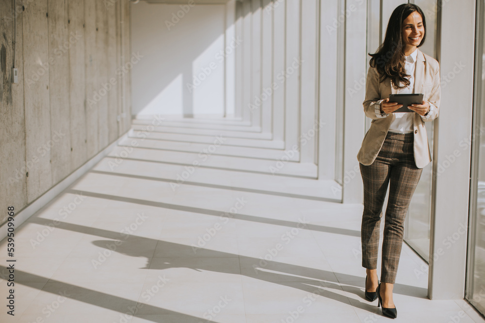 Young businesswoman walking on modern office hallway