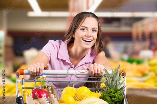 Happy woman buying food in big supermarket