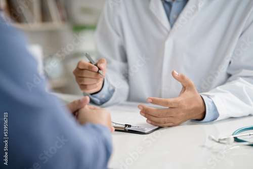 Closeup of doctor sitting patient talk and inquire consulting for diagnostic to make appointments and write prescriptions healthcare  medical service  consultation  healthy lifestyle concept.