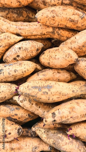 The texture of a pile of sweet potatoes that is in the supermarket