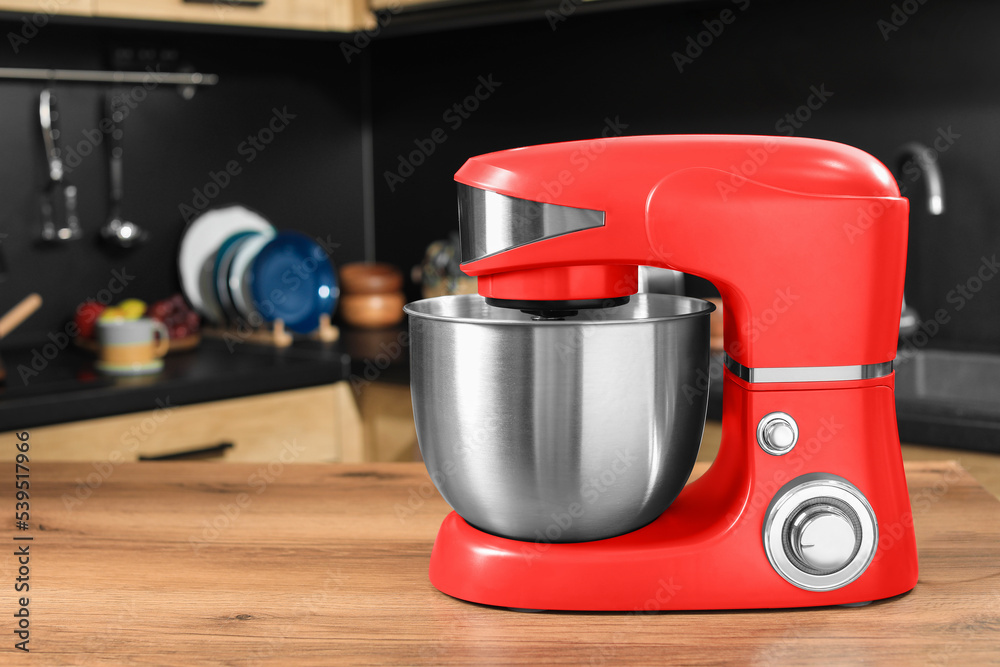 Modern red stand mixer on wooden table in kitchen Modern red stand mixer on wooden table in kitchen