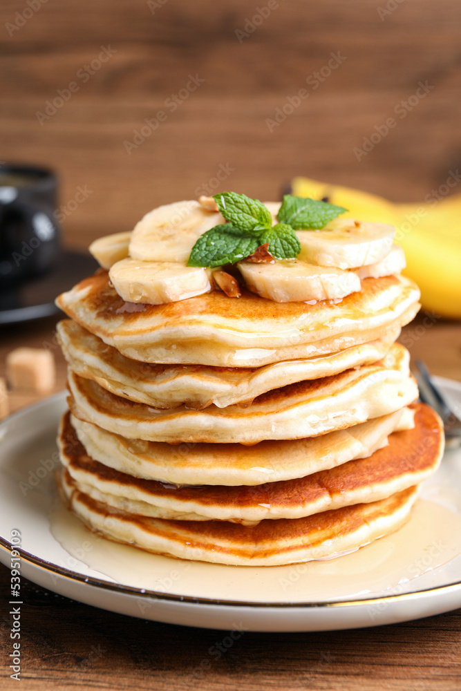 Tasty pancakes with sliced banana on wooden table, closeup Tasty pancakes with sliced banana on wooden table, closeup