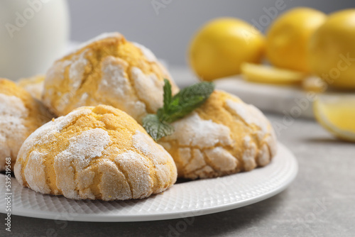 Plate with delicious lemon cookies and mint on grey table, closeup