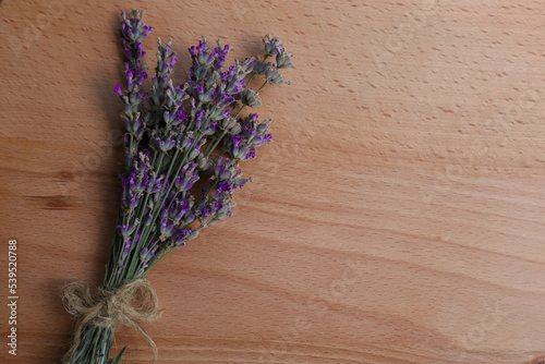 Bouquet of beautiful lavender flowers on wooden table, top view. Space for text