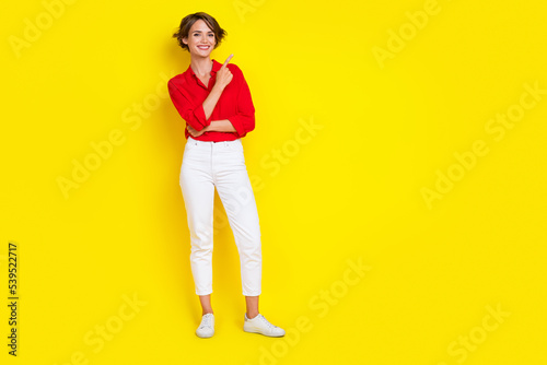 Full body photo of positive charming lady direct finger empty space promotion isolated on yellow color background