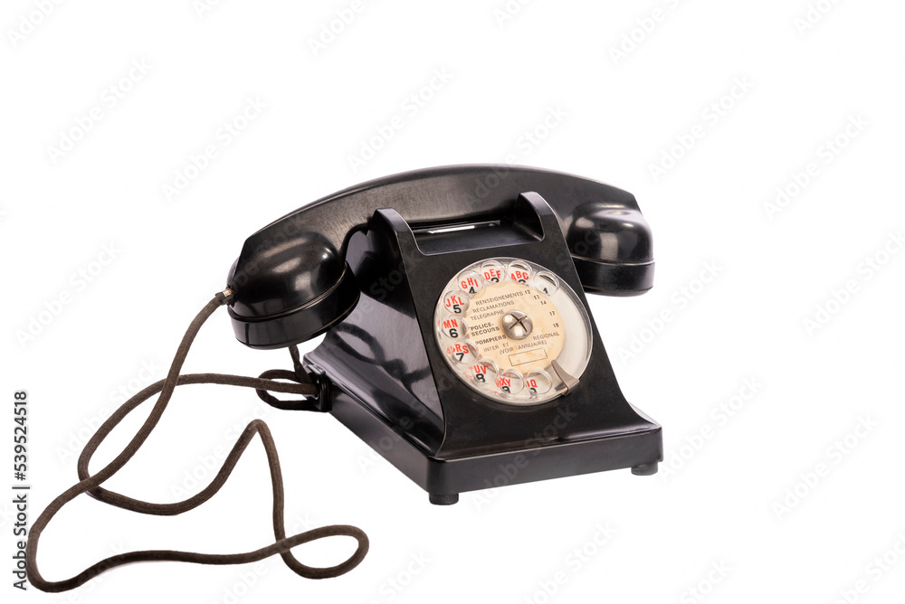 Ancien téléphone fixe noir des PTT vu de 3/4 sur un fond blanc packshot