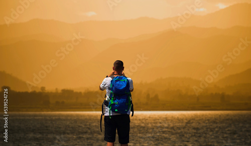Man stands on the edge of the abyss and looks at the sea. Man relax on nature. freedom man.
