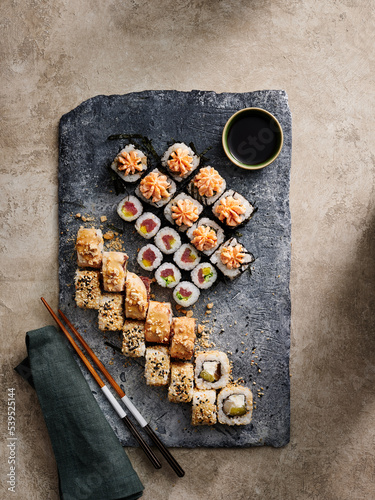 Minimalistic and clean maki sushi set on stone serving board on light background photo