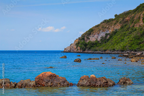 Coast and rock with background  is mountain and blue sky