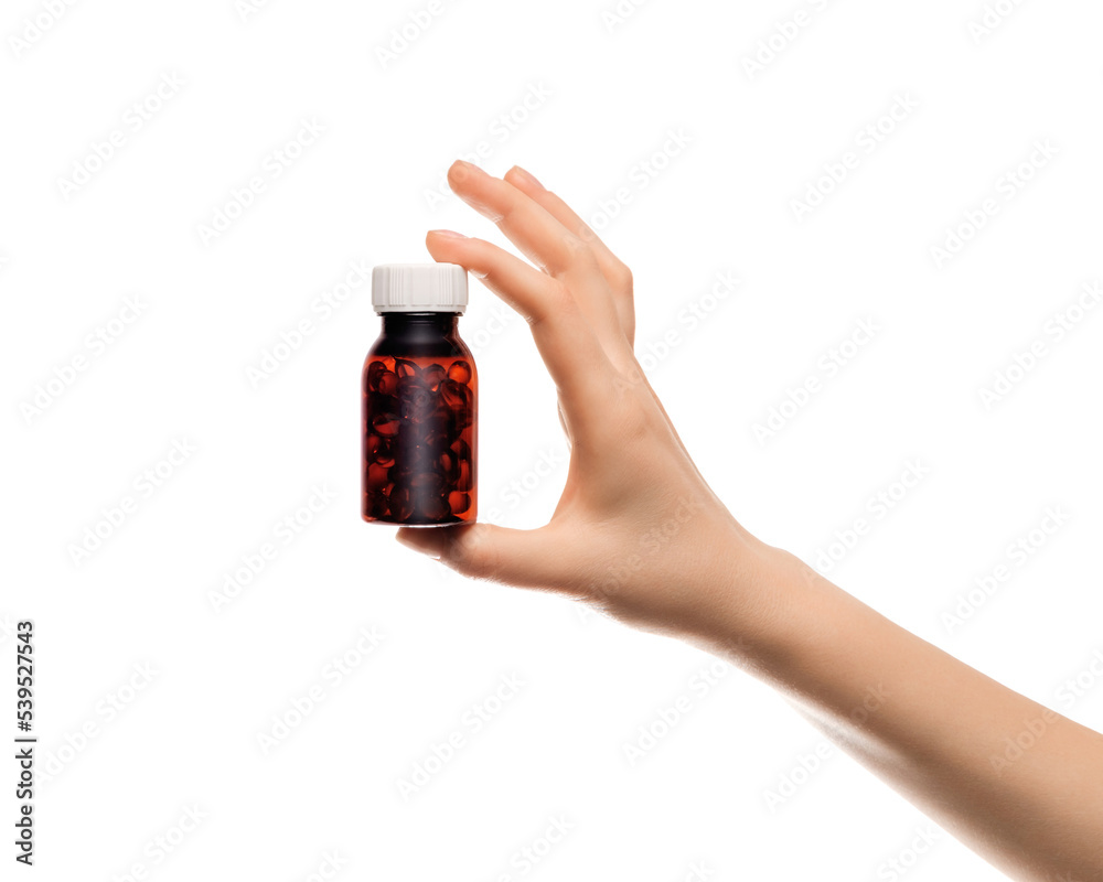 A jar filled with fish oil pills in a woman's hand, isolated on white. A jar filled with fish oil pills in a woman's hand, isolated on white.