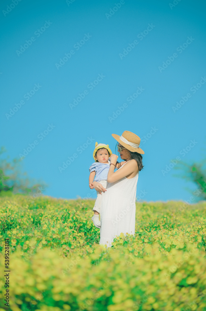 mother with little child in white blooming garden. woman with son in green leaves,happy family outdoors in spring mother with little child in white blooming garden. woman with son in green leaves,happy family outdoors in spring