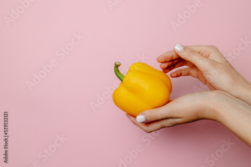 hand holding yellow pepper
