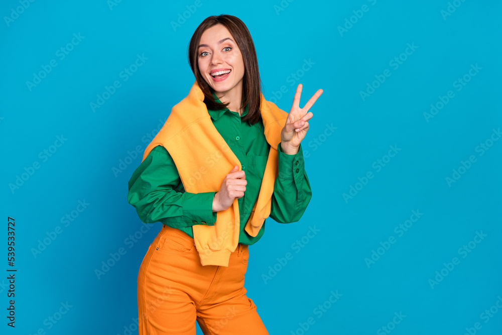 Photo of nice cheerful person hand fingers demonstrate v-sign isolated on blue color background Photo of nice cheerful person hand fingers demonstrate v-sign isolated on blue color background