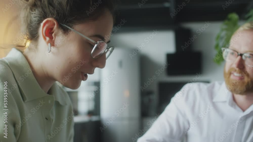 Financial planner speaking with young woman as she sighing agreement during consultation at home Financial planner speaking with young woman as she sighing agreement during consultation at home